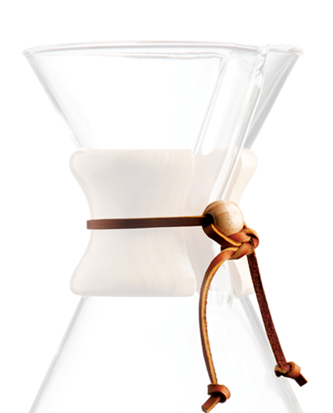 Et nærbillede af en Chemex kaffemaskine, med en glaskrop med en trækrave fastgjort med en læderrem med en træperle. Designet er elegant og enkelt og viser kaffemaskinen.