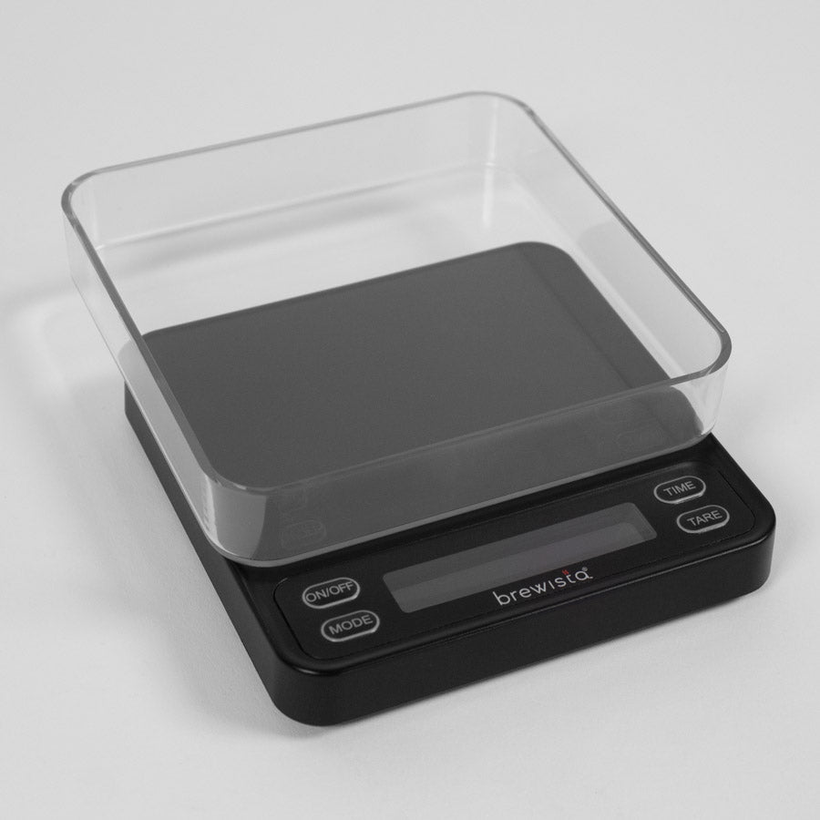 Brewista Smart Scale 3 tilbyder et minimalistisk design med en klar plastbakke og intuitive "ON/OFF", "MODE", "TIME" og "TARE" knapper. Ideel til espresso eller drop, dets centrale digitale display giver præcise målinger.