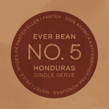 En cirkulær brun etiket viser teksten: "EverBean Single Serve, No. 05 · Honduras." Mindre tekst nævner: "100% Arabica kaffebønner fra Honduras," understreger dens søde karamel og mørk chokolade noter og gør den ideel til nydelse på farten. Ristet af Livjele.