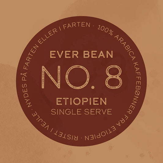 Brun cirkulær kaffeetiket med "Single Serve, No. 08 · Etiopien" i midten. Den omkringliggende tekst lyder "100% Arabica kaffebønner fra Etiopien" og "Nydes på farten eller i ro," med mærkenavnet EverBean vist.